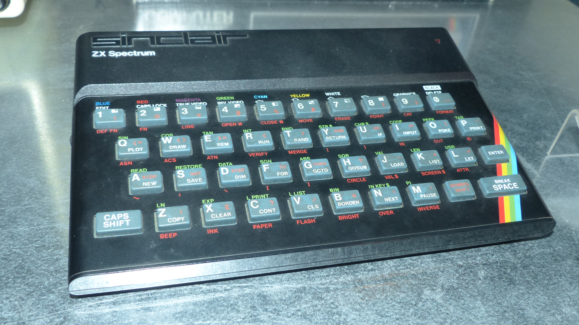 A Sinclair ZX Spectrum 48K computer on display, showing its rainbow-striped case and rubber keyboard